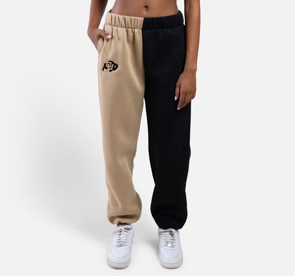 Two toned color blocked sweatpants, where the right leg is gold and the left leg is black. There is also the CU Buffalo logo embroidered on the upper right leg.